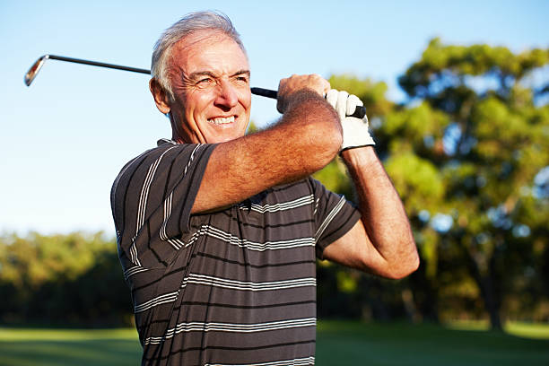 mature golfeur se balancer - golf playing teeing off men photos et images de collection