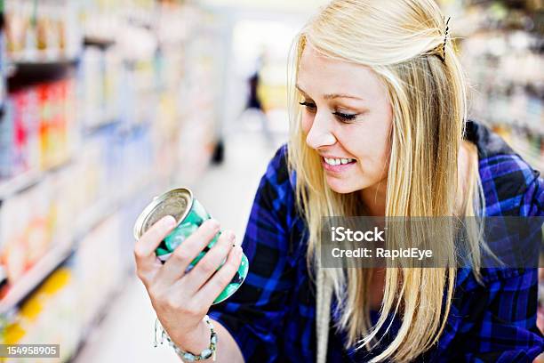 Bonita Loira Smilingly Verificar Enlatado Mercadorias No Supermercado - Fotografias de stock e mais imagens de Etiquetar