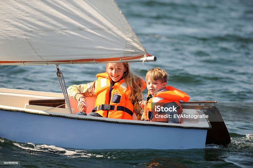 Two kids sailing in small vessel Sister and her brother with down syndrome are sailing in a small boat. Child Stock Photo