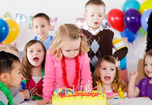 A group of children celebrate at a birthday party.