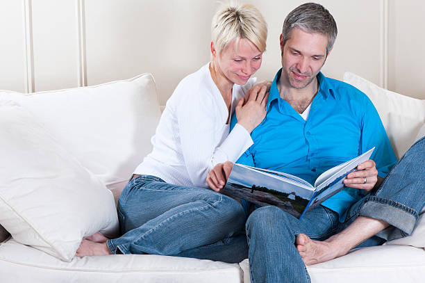 istock Couple relaxing and reading on a couch. 154959346
