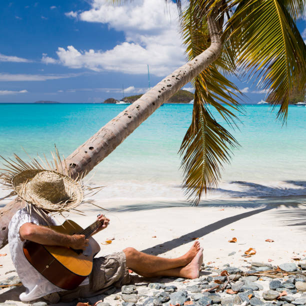 istock man playing guitar at a beach in the Caribbean 154959392