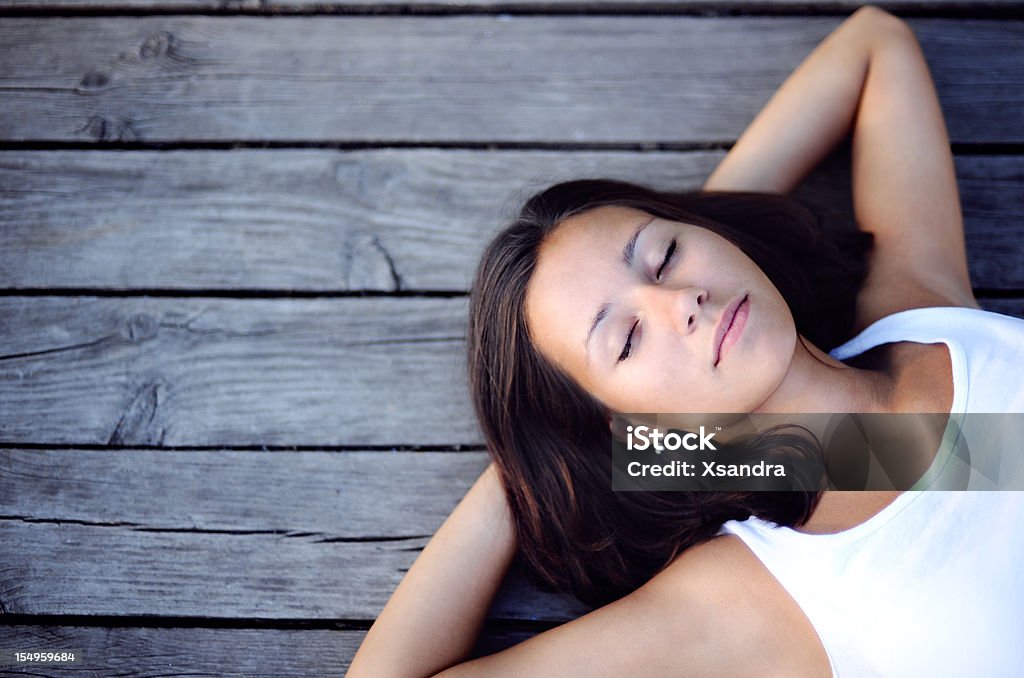 Jeune fille allongée sur une jetée - Photo de 20-24 ans libre de droits