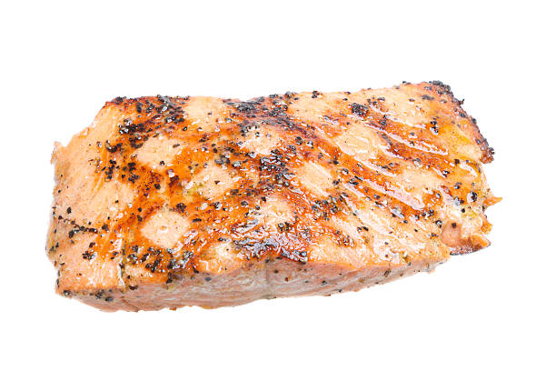 Healthy grilled salmon filet seasoned perfectly with perfect diamond shaped grill marks isolated on white