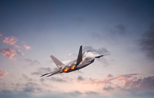 Advanced military aircraft flying into the sunset