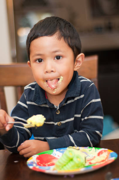 istock boy enjoy eating a birthday cake 154960220