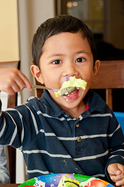 istock boy enjoy eating a birthday cake 154960221
