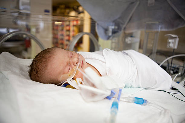 Sleeping newborn in hospital bed stock photo