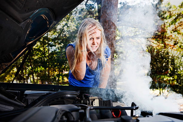 istock Beautiful blonde with broken down car holds head in despair 154960532