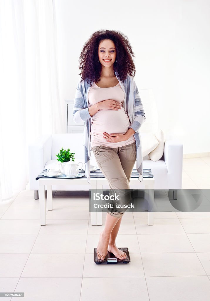 Smiling pegnant woman weighting herself  Pregnant Stock Photo