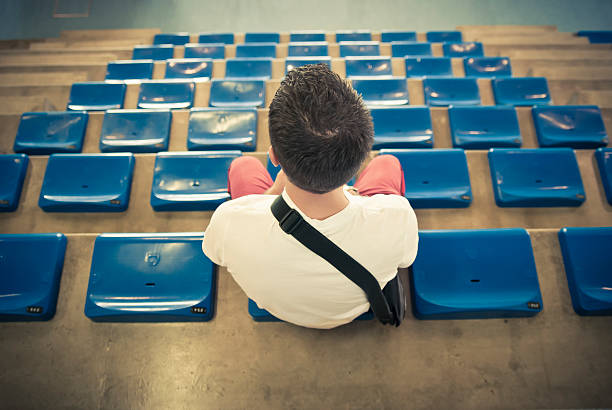 lonely man on the empty stadium seat cheering for the team, one man army concept