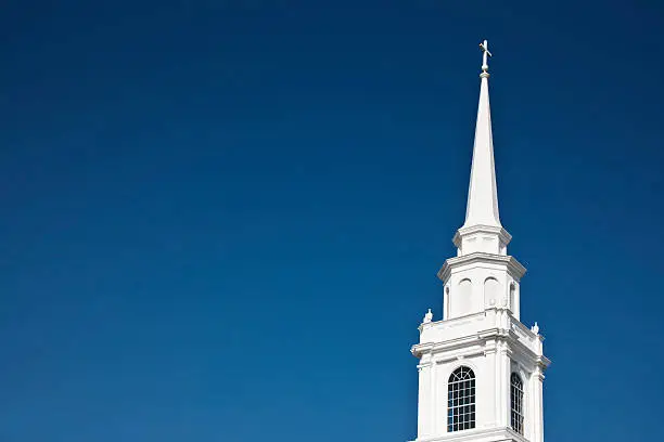White church steeple against a clear blue sky. Space for copy.