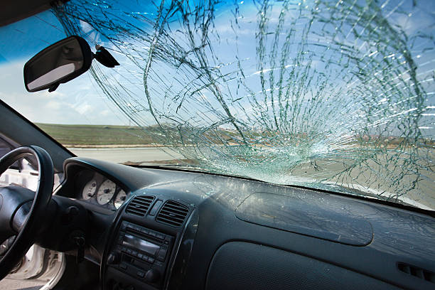 Inside of car with the broken windshield. Road accident Inside of the car with windshield that was broken in car accident where the walker is injured. Car is on the road. Photo taken with wide lens windshield stock pictures, royalty-free photos & images