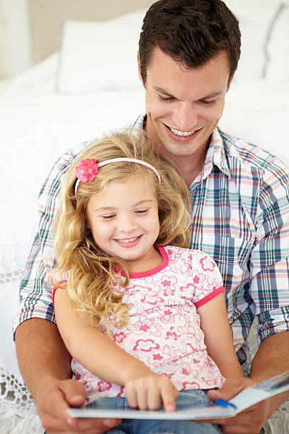 istock Father And Daughter Reading Book In Bedroom 154961421