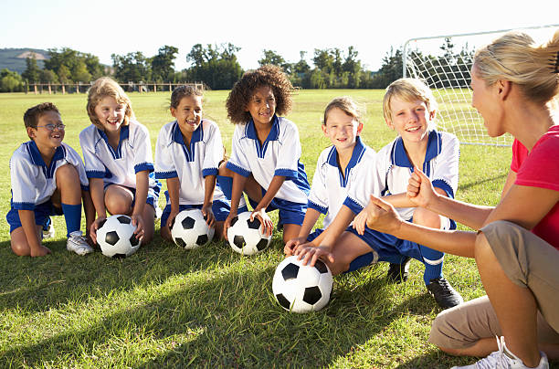niños en el equipo de fútbol con el entrenador con capacitación hembra - soccer child coach childhood fotografías e imágenes de stock