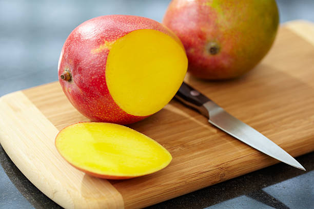 istock A freshly sliced mango on wooden cutting board 154961748