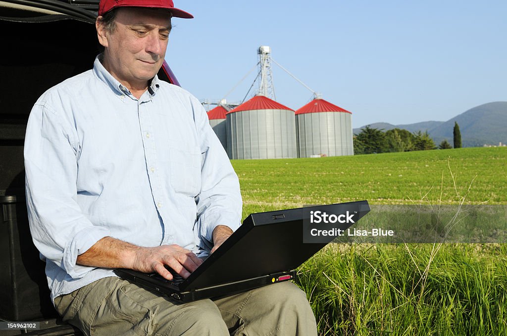 Agricoltore utilizzando PC in campagna - Foto stock royalty-free di Ingegnere