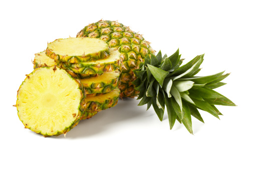 Sliced pineapple with whole pineapple isolated on white background.