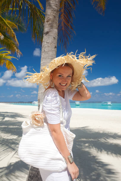 istock beautiful woman in white under palmtree 154962295