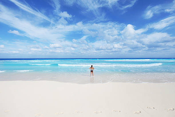 Ultra wide angle photo of serene woman enjoying a tropical seascape. Shot with Canon L Series Ultra Wide 14mm lens. Lots of great cropping options in this file. Cancun, Mexico.