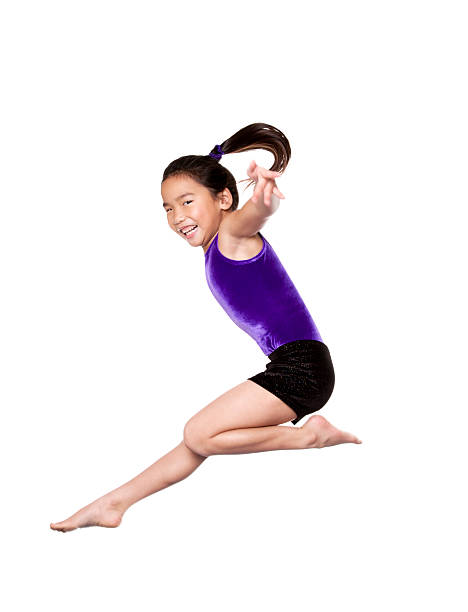 A young woman performs a dynamic handstand in bright sportswear against a vivid blue background, capturing energy, positivity, and a passion for fitness.