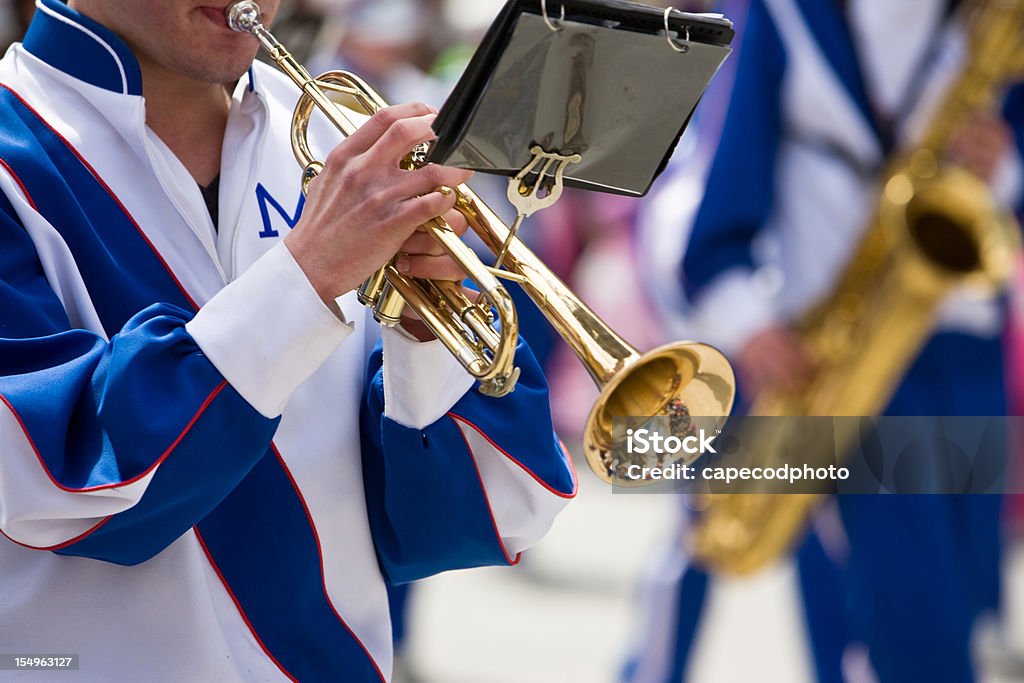 Playing Trumpet in the Parade A trumpet player plays while marching in a parade Marching Band Stock Photo