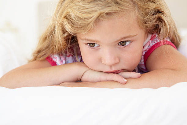 istock Young Girl Looking Sad Laying On Bed 154963171
