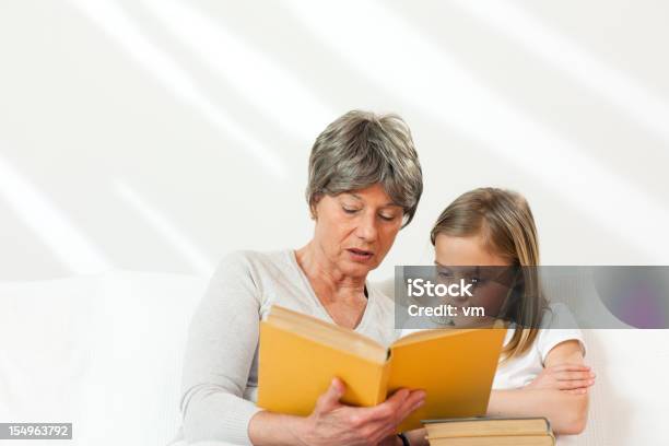 Senior Woman Reading Für Kleine Mädchen Stockfoto und mehr Bilder von 6-7 Jahre - 6-7 Jahre, 60-69 Jahre, Alter Erwachsener