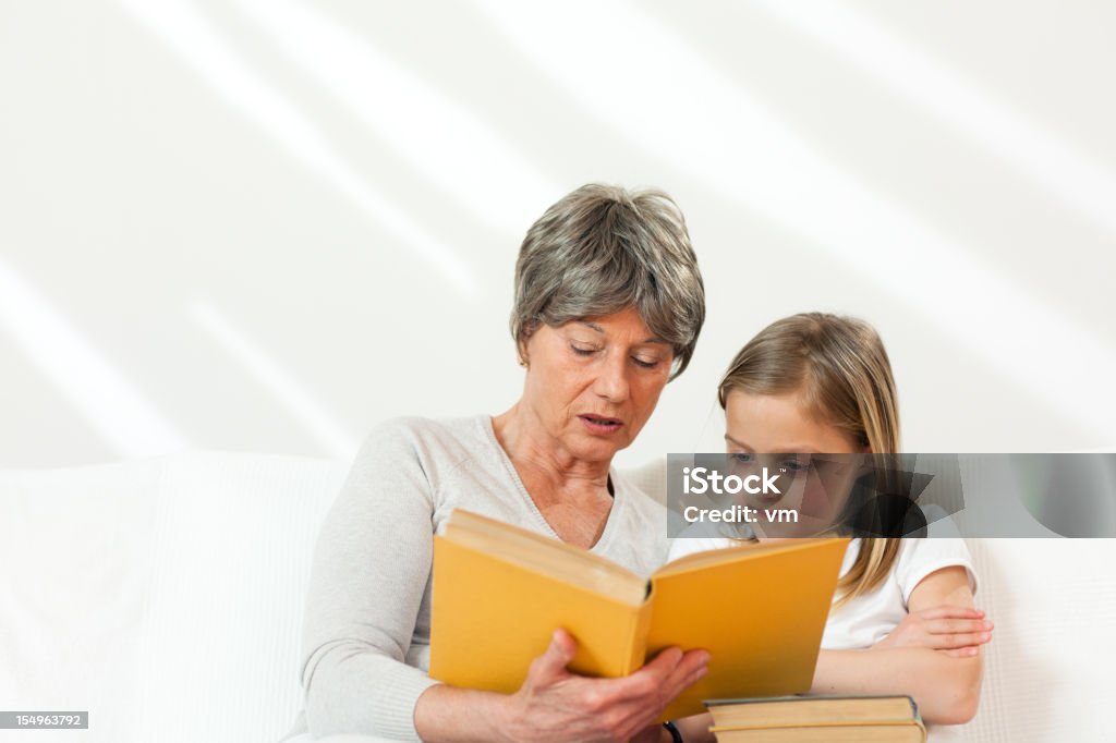 Senior Woman Reading a Little Girl - Foto de stock de 6-7 años libre de derechos