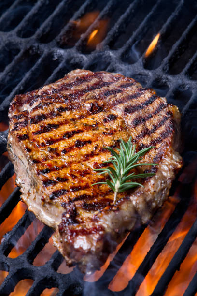 Ribeye Steak on Grill Ribeye Steak on Grill with Rosemary Sprig porterhouse steak stock pictures, royalty-free photos & images