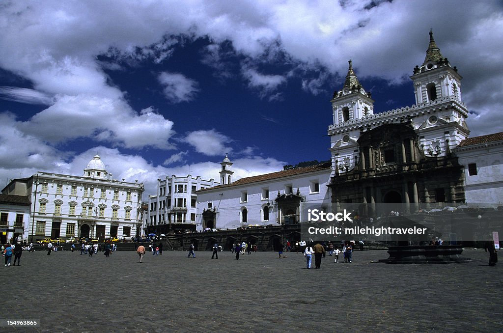 People walk on Plaza de San Francisco, Quito Ecuador Visitors and locals enjoy walking in the Plaza de San Francisco in Quito Ecuador. The Spanish church Iglesia de San Francisco on the right, was the first church built in Quito. Construction began in 1535, just one month after the Spanish arrived and took more than 100 years to finish. The plaza is thought to be built over an Incan temple. Hotels and other historic buildings stand nearby. Architectural Column Stock Photo