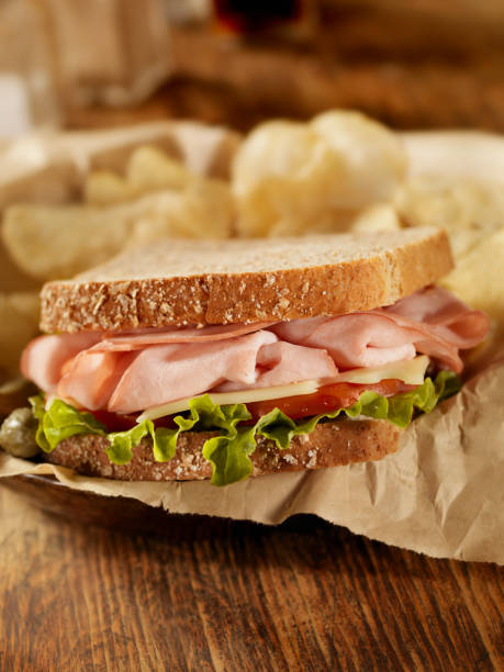 Club sandwich with French fries on a white plate. Close up