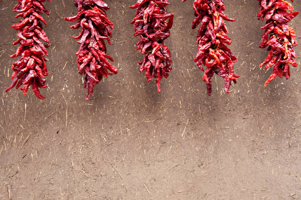 chili peppers ristras na adobe ściany - ristra zdjęcia i obrazy z banku zdjęć