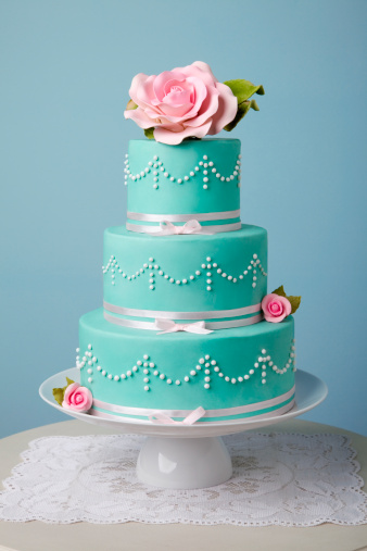 three tire turquoise cake decorated with flower