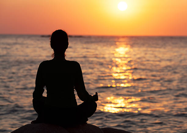 istock Woman meditating on sunrise 154964497
