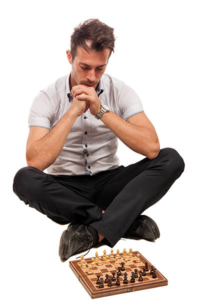 Serious focused man thinks on game of chess isolated on white