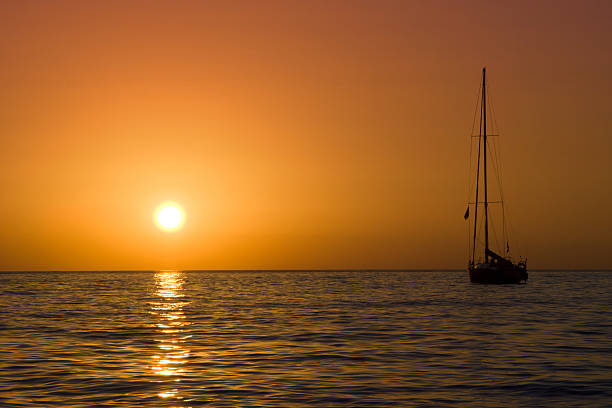 sailboat and sea sunset stock photo