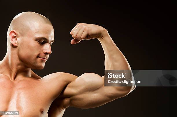 Cuerpo Builder Flexión Biceps Foto de stock y más banco de imágenes de Abdomen - Abdomen, Abdomen humano, Adulto