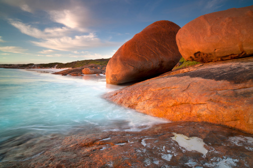 Giant granite boulders on the beach at Lucky Bay illuminated by the last light of the day. Cape Le Grande National Park, Esperance, Western Australia.