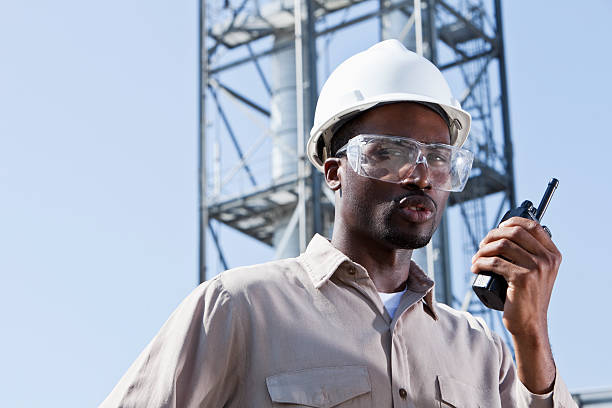 lavoratore industriale con walkie-talkie - manufacturing occupation african descent refinery manual worker foto e immagini stock