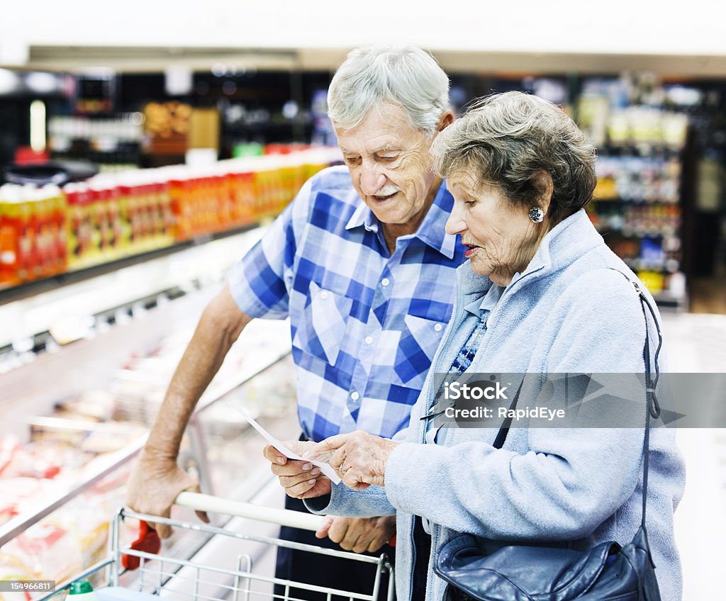Веселый Старший пара Проверьте свой список покупок в Супермаркет - Стоковые фото Пожилой возраст роялти-фри