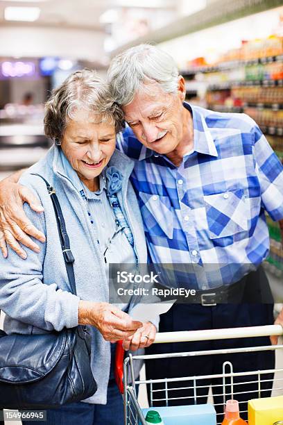 Carinhoso Casal Idoso Verifique A Lista De Compras No Supermercado - Fotografias de stock e mais imagens de Abraçar
