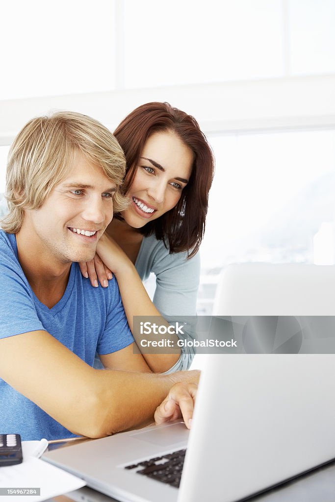 Ritratto di una giovane coppia usando il portatile insieme - Foto stock royalty-free di Abbigliamento casual