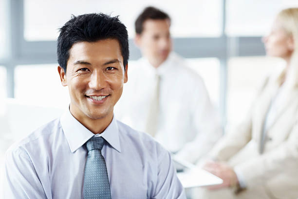 istock Smiling businessman with colleagues behind 154967306