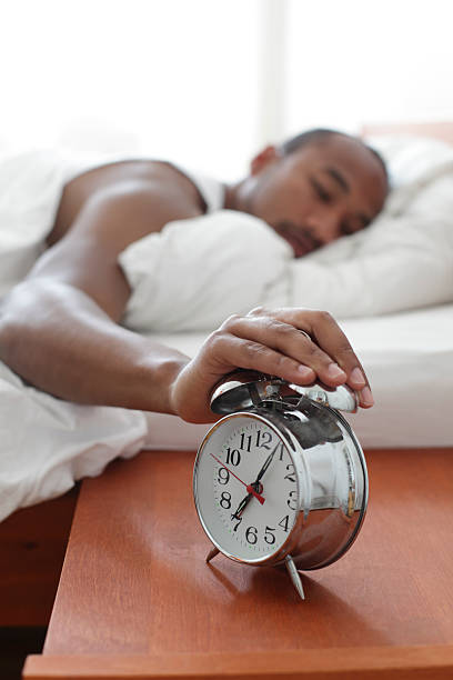 Alarm Clock on bedside table [url=http://www.istockphoto.com/search/lightbox/10593543][img]http://www.vela-photo.com/istock/jon.jpg[/img][/url] 
Man of afro american descent sleeping next to his bedside alarm clock
[url=file_closeup.php?id=16554881][img]file_thumbview_approve.php?size=1&id=16554881[/img][/url] [url=file_closeup.php?id=16531278][img]file_thumbview_approve.php?size=1&id=16531278[/img][/url]
[url=http://www.istockphoto.com/search/portfolio/454906][img]http://bit.ly/18OpGAk[/img][/url] alarm clock snooze stock pictures, royalty-free photos & images