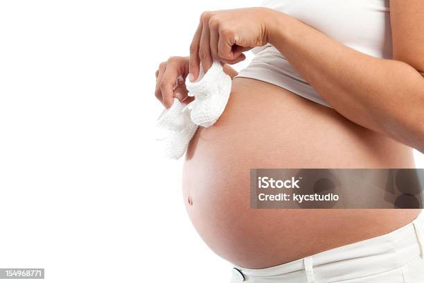 Schwangere Frau Mit Babystiefeletten Stockfoto und mehr Bilder von Abwarten - Abwarten, Babyschuh, Bauch