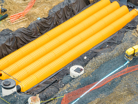 Yellow underground storm water detention mitigation units on a construction site ready to be covered.  Abstract rounded shape.