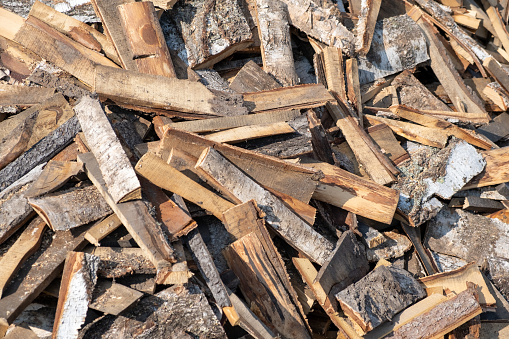 A large pile of different sawn firewood for the stove. Preparing firewood for the winter. Firewood background.
