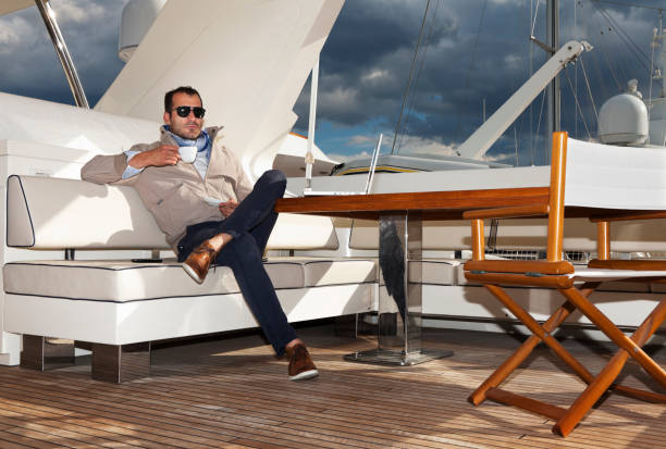 Businessman on the yacht drinking coffee and relaxing stock photo