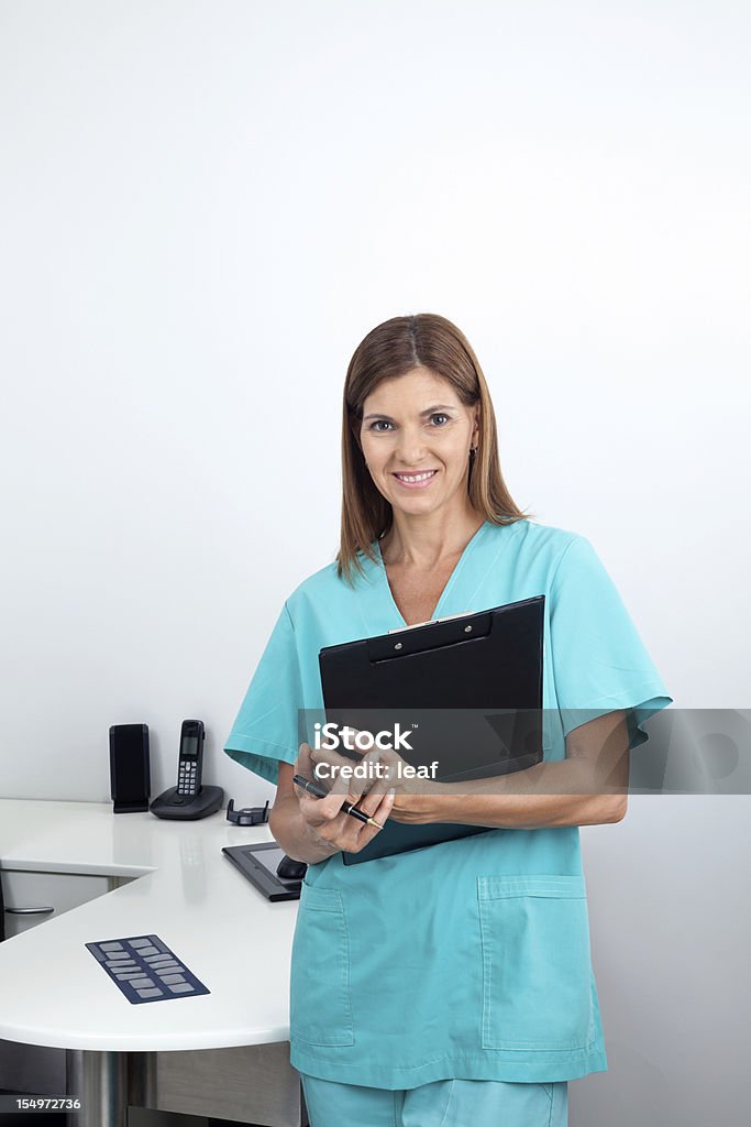 Female Dentist Holding Clipboard In Clinic Portrait of a happy female dentist holding clipboard in dental clinic Adult Stock Photo